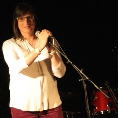 Photo of the author on stage holding 
a microphone
